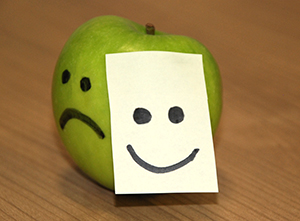 Apple with sad and happy faces