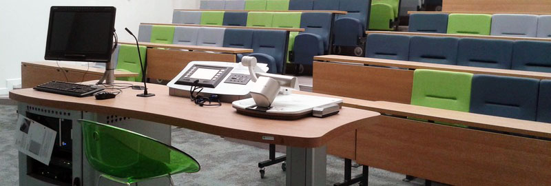 A picture of a lecture theatre with some Audio Video equipment in the foreground.
